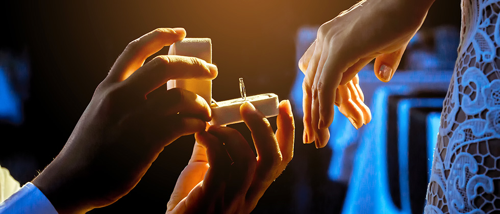 Close-up of a man offering a ring box to his partner