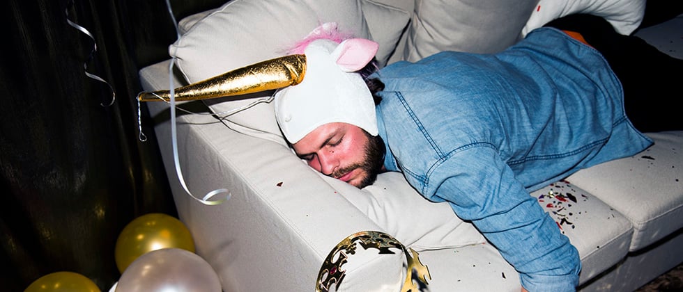 Drunk man passed out on a sofa at a party