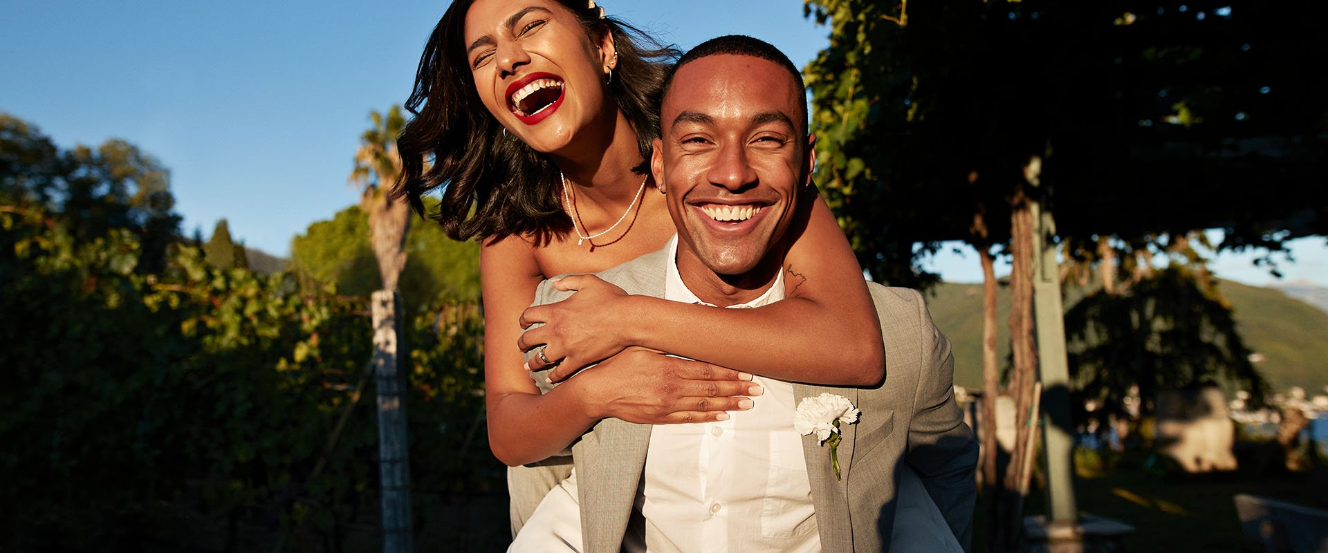 A happy couple having fun outside with her on his back 