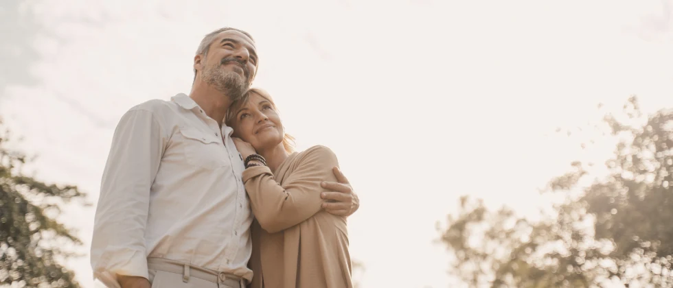 A couple hugging each other in the nature.