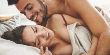A young couple being playful in bed in the morning
