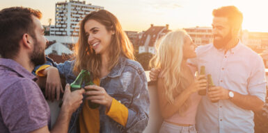 Two couples standing on a roof top talking to their partners