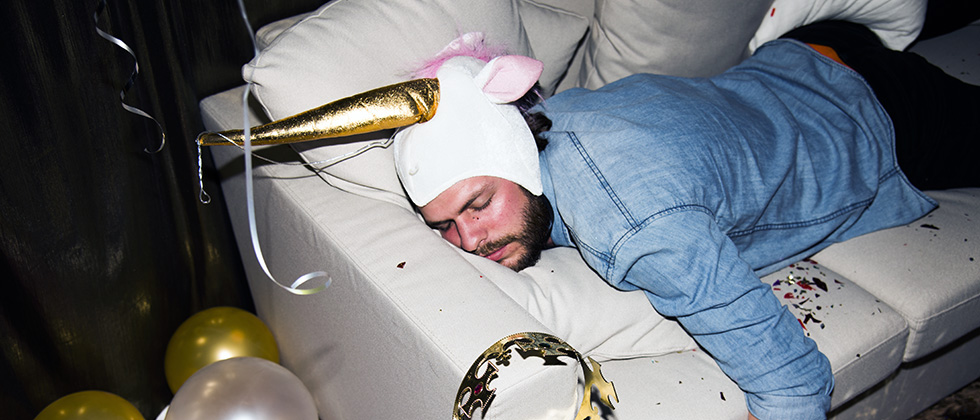 Drunk man passed out on a sofa at a party