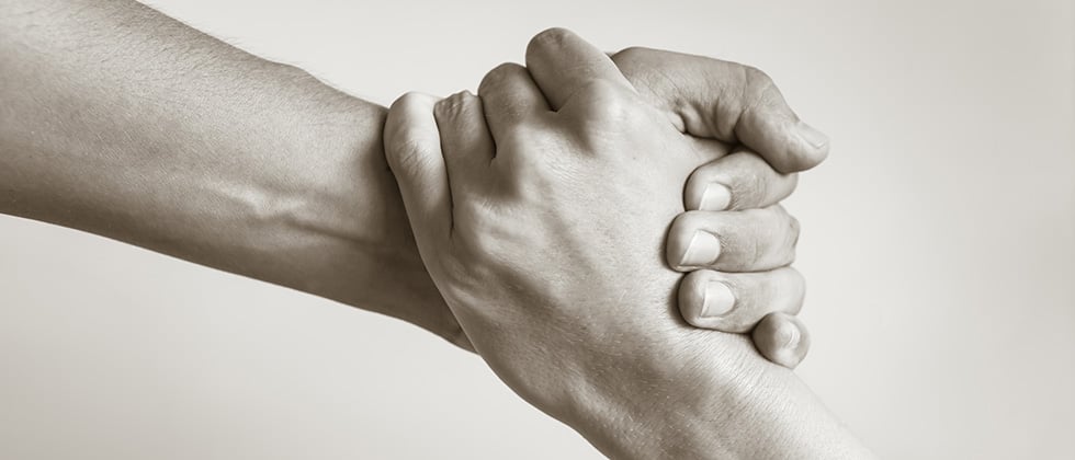 Close-up of a man and woman's hands clasped together