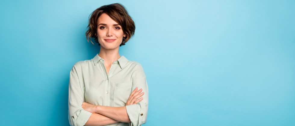 A woman with her arms crossed looking confidently into the camera