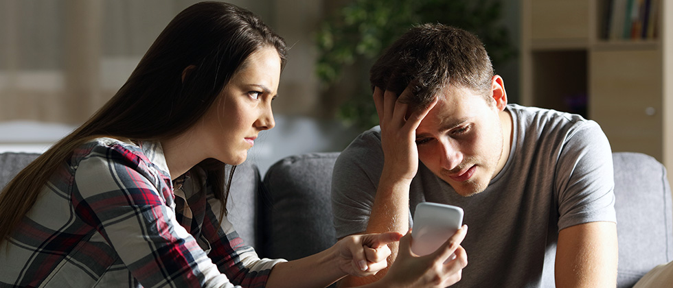 A woman confronts her boyfriend with evidence of infidelity on his phone