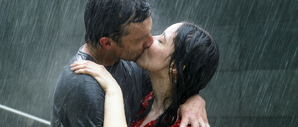 A couple kiss passionately in the pouring rain