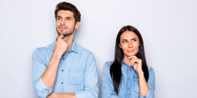 A couple standing looking suspicious - both looking in opposite directions