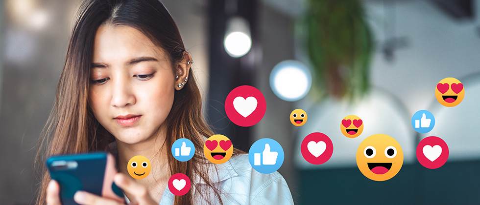 A young woman looks at her phone while animated social media icons float across the picture