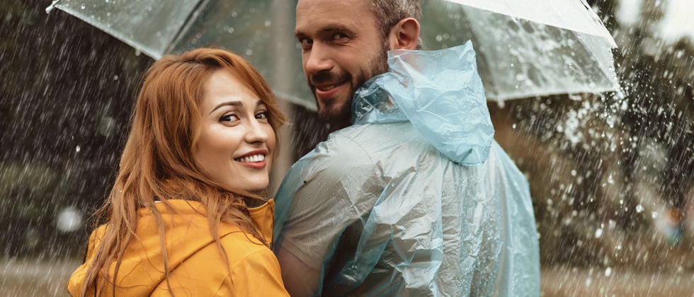 Couple caught in the rain under an umbrella together