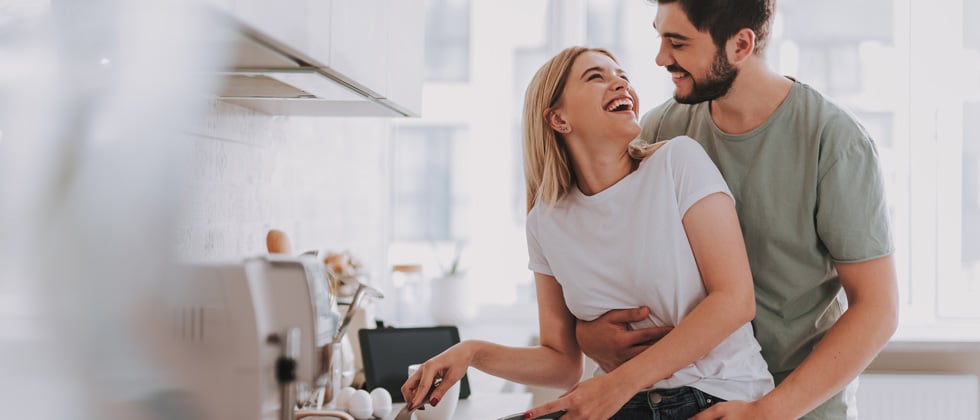 Couple in the kitchen cooking and laughing together