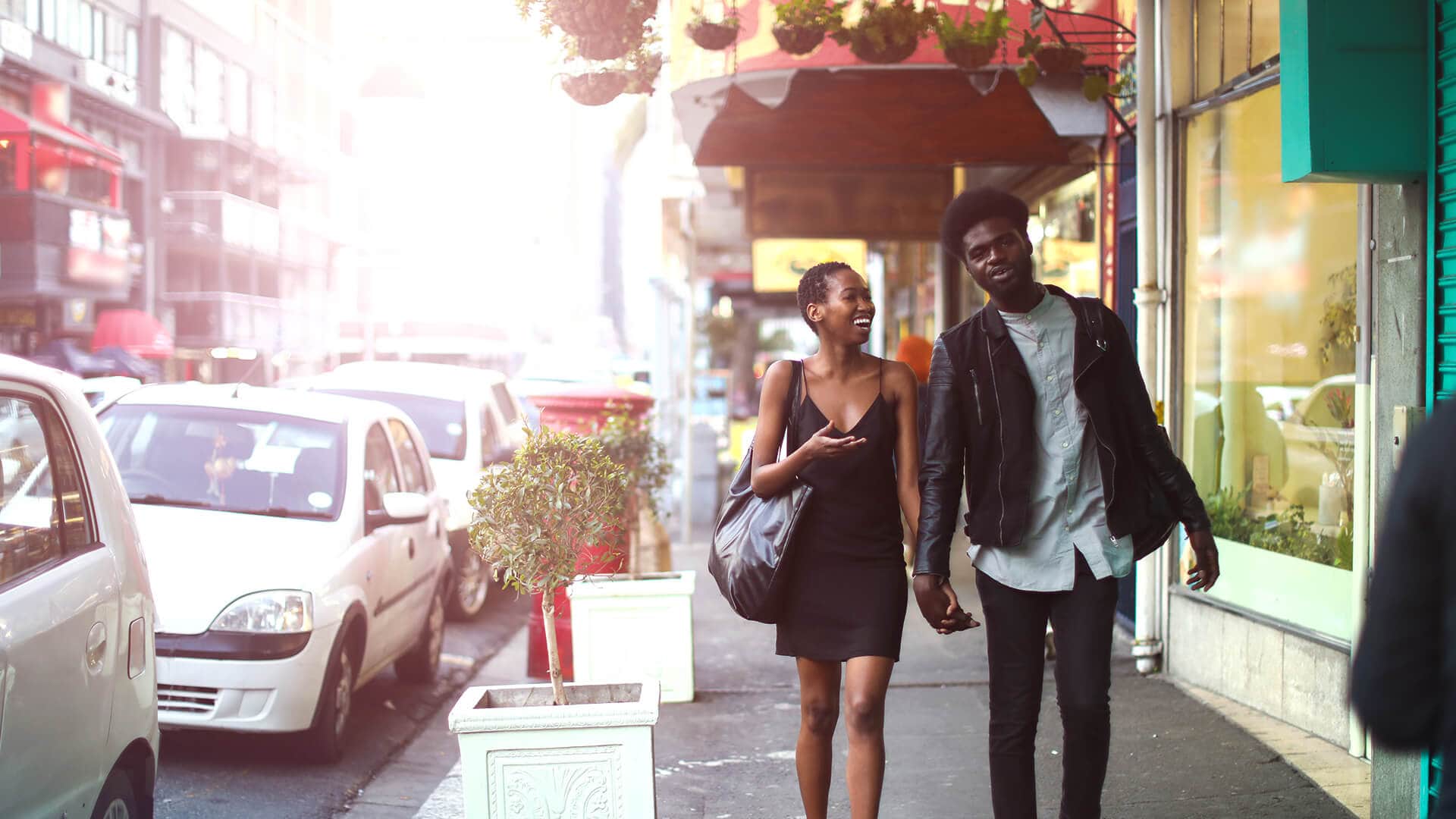 African dating symbolized by a man and woman strolling hand in hand through the city on their first date