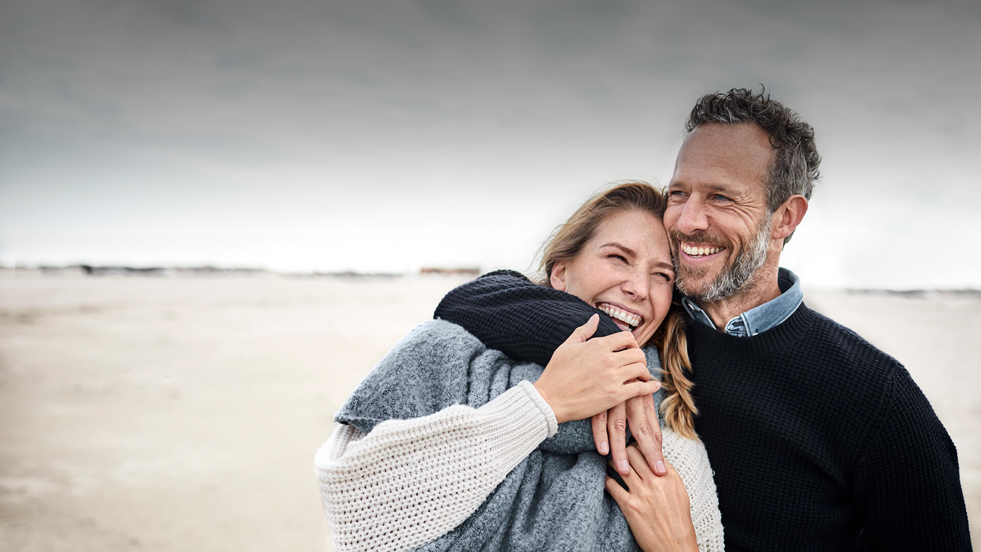 Catholic dating symbolized by a man who hold a woman in his arms at the beach