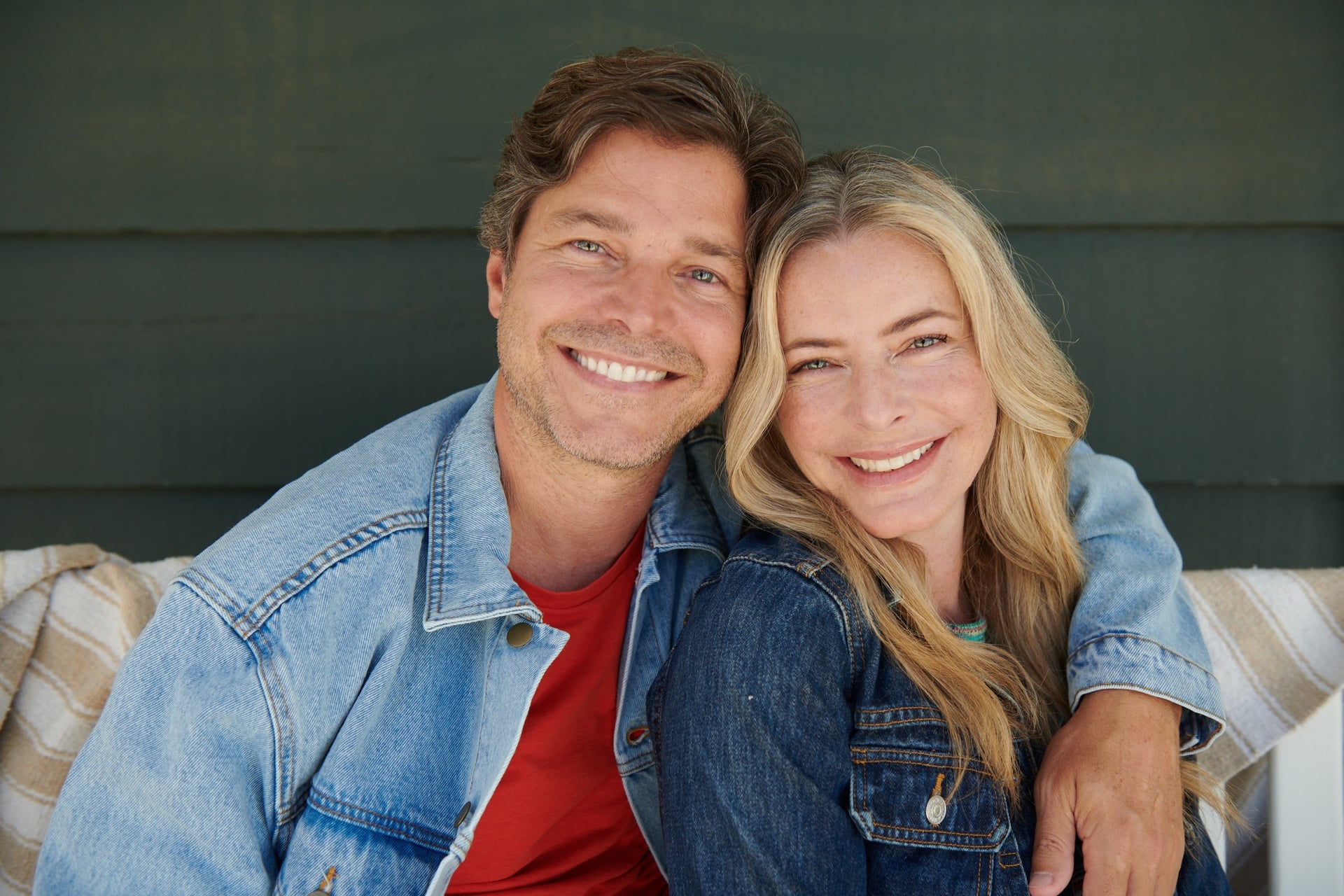 Woman and man over 50 smiling into camera as a couple