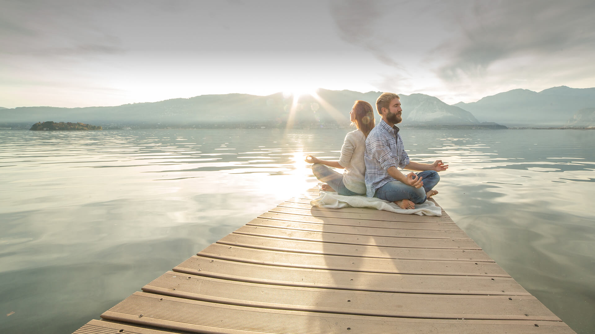 Spiritual dating symbolized by a couple meditating together on a dock