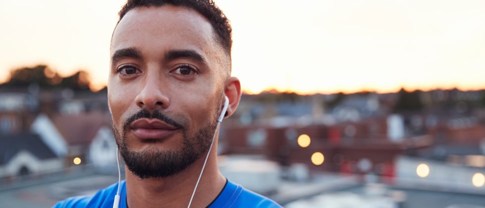 Shorter man softly looking directly into camera