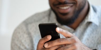 Guy texting on his cell phone and smiling