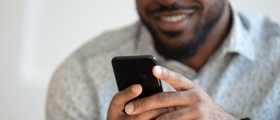 Guy texting on his cell phone and smiling