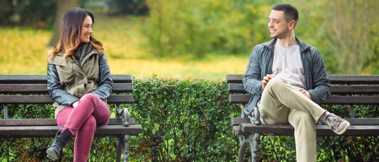 Man and woman sitting on the bench - she thinks about how to ask a guy out