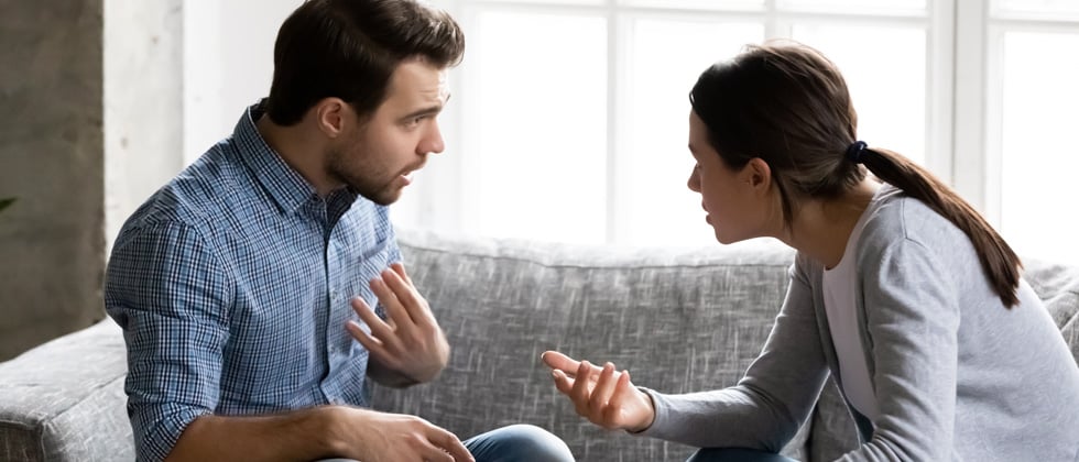 A couple having a heated argument on their couch