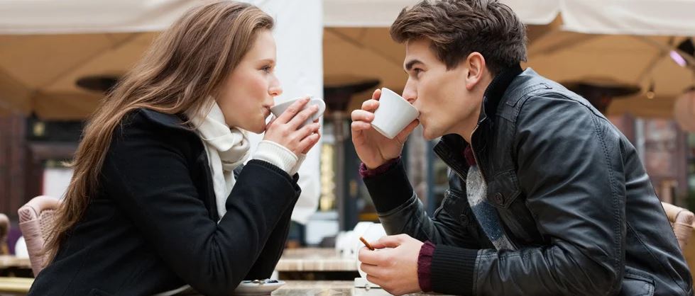 Man and woman on a coffee date look into each other's eyes