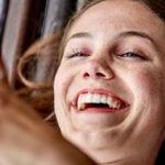Woman on mobile smiles and has a phone date