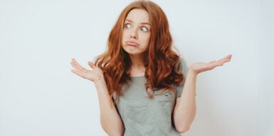 Girl looks amazed and raises hands in the air as a symbol of questions that you can ask a girl