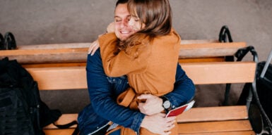 Man sitting on a bench with a woman on his lap as a symbol of how long-distance relationships can work.