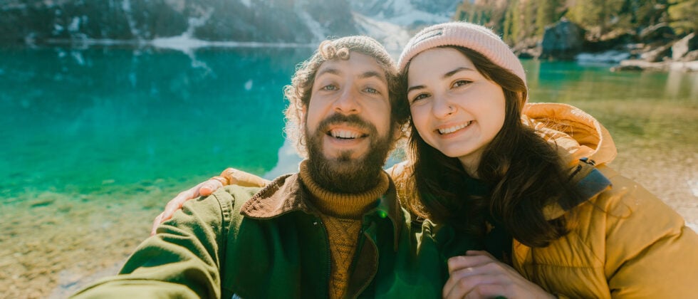 Man and woman smile in camera as an example of compatibility in a relationship