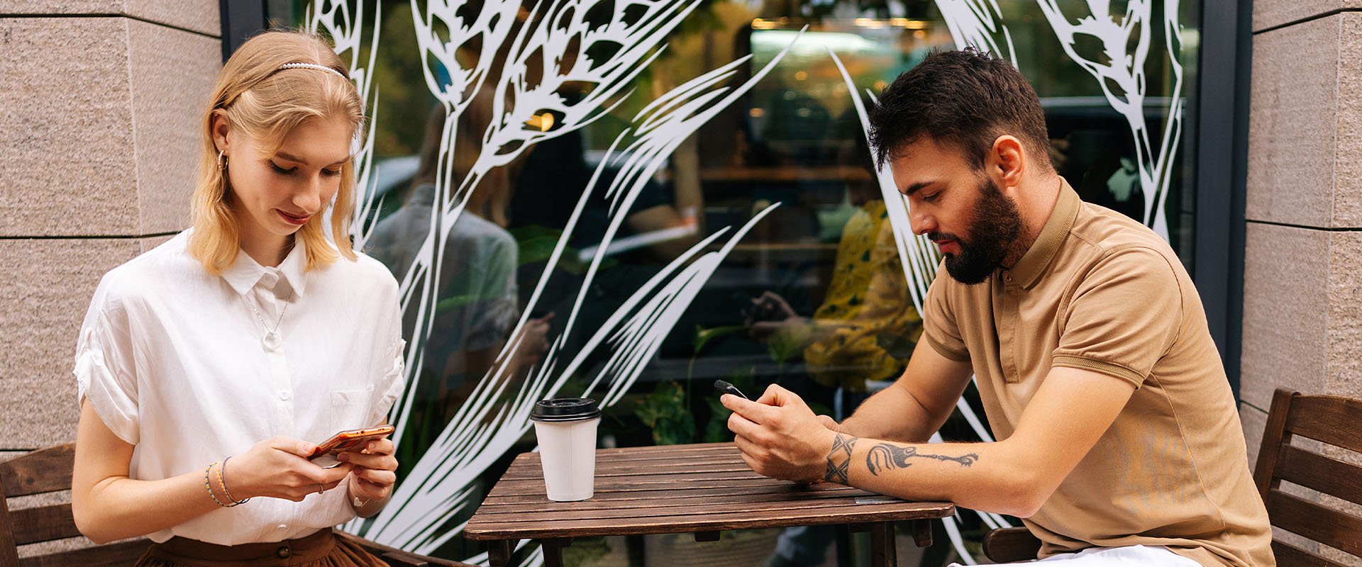 Man and woman both sitting on cell phone as symbol for dating red flags