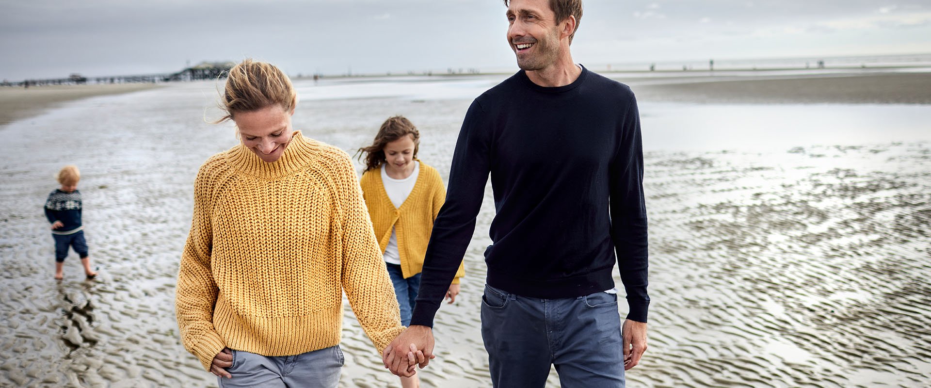 Man and woman with two children on beach as symbol for dating with kids