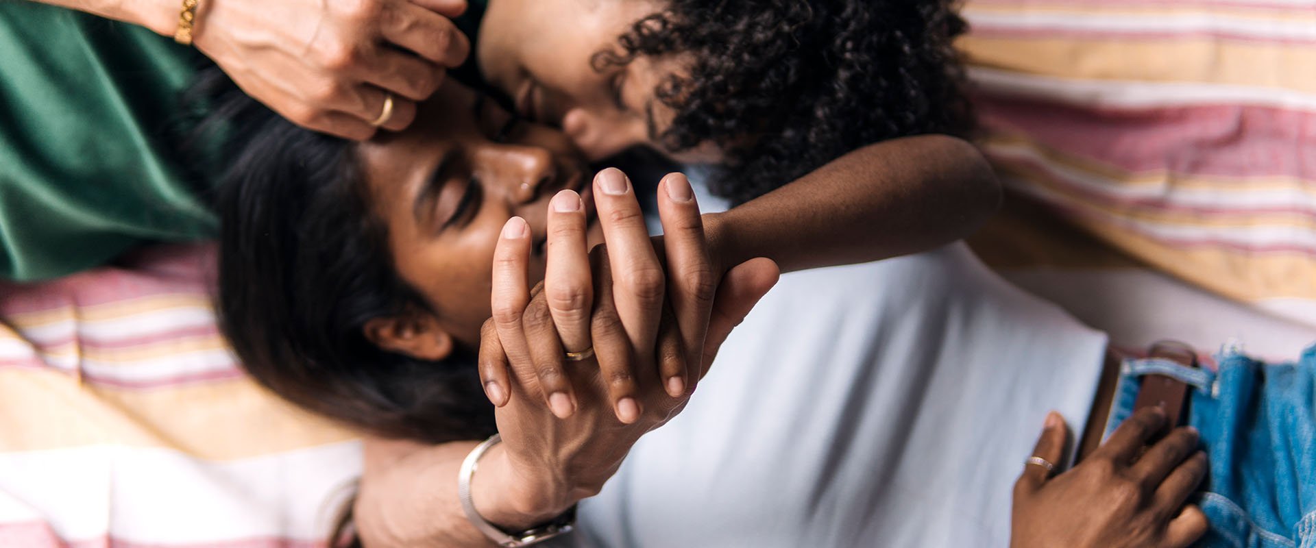 Man and woman lying close together with hands crossed as a symbol of how dou you know if someone loves you