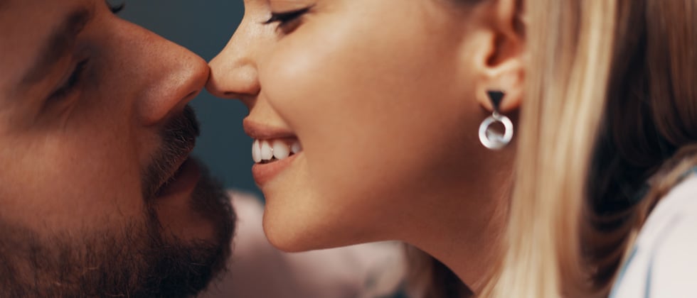 A close up of a couple about to share an intimate kiss