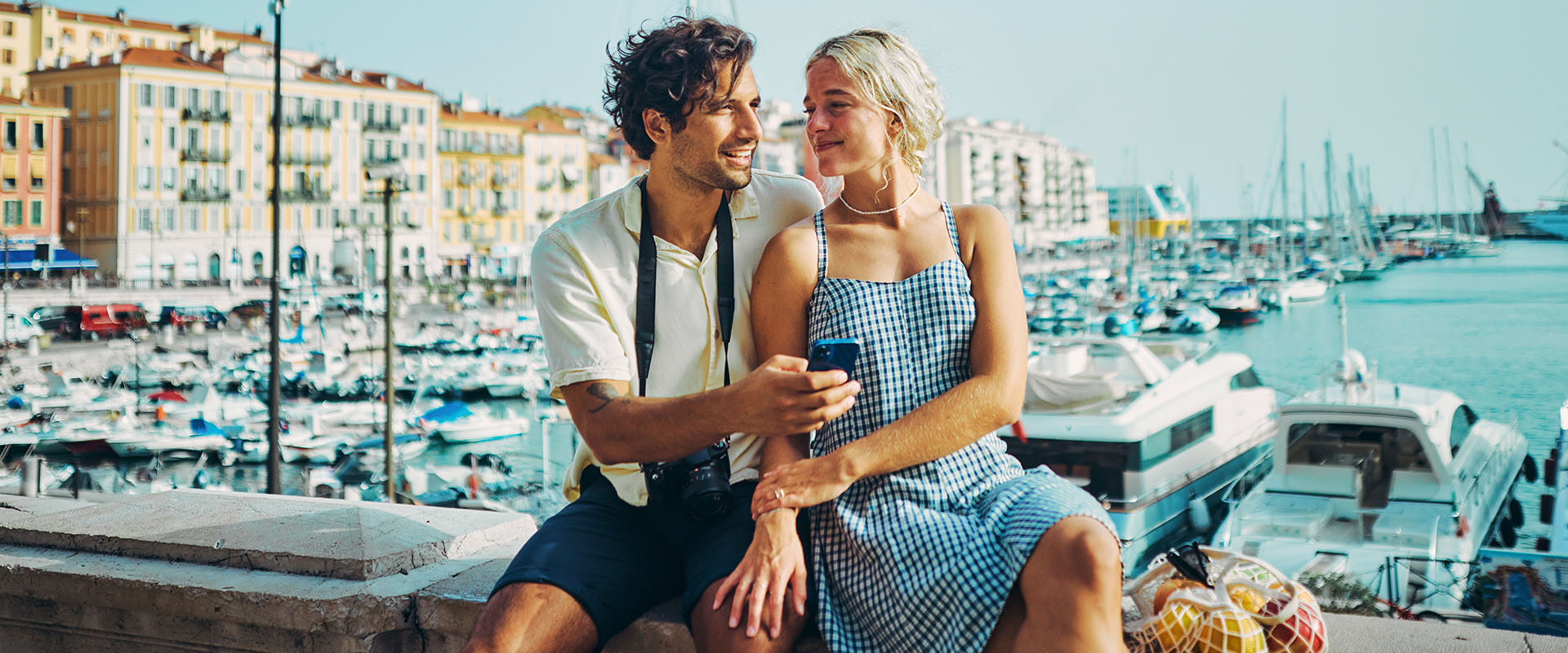 Man and woman sitting together at the harbor looking at each other as a symbol of how to get a boyfriend