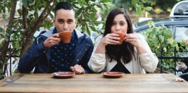 Man and woman drink coffee together and look at camera as symobl for rebound relationship