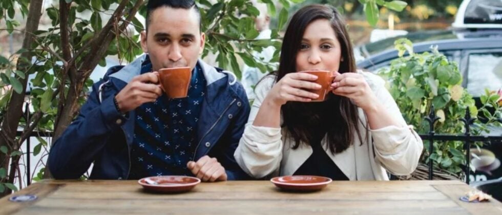 Man and woman drink coffee together and look at camera as symobl for rebound relationship