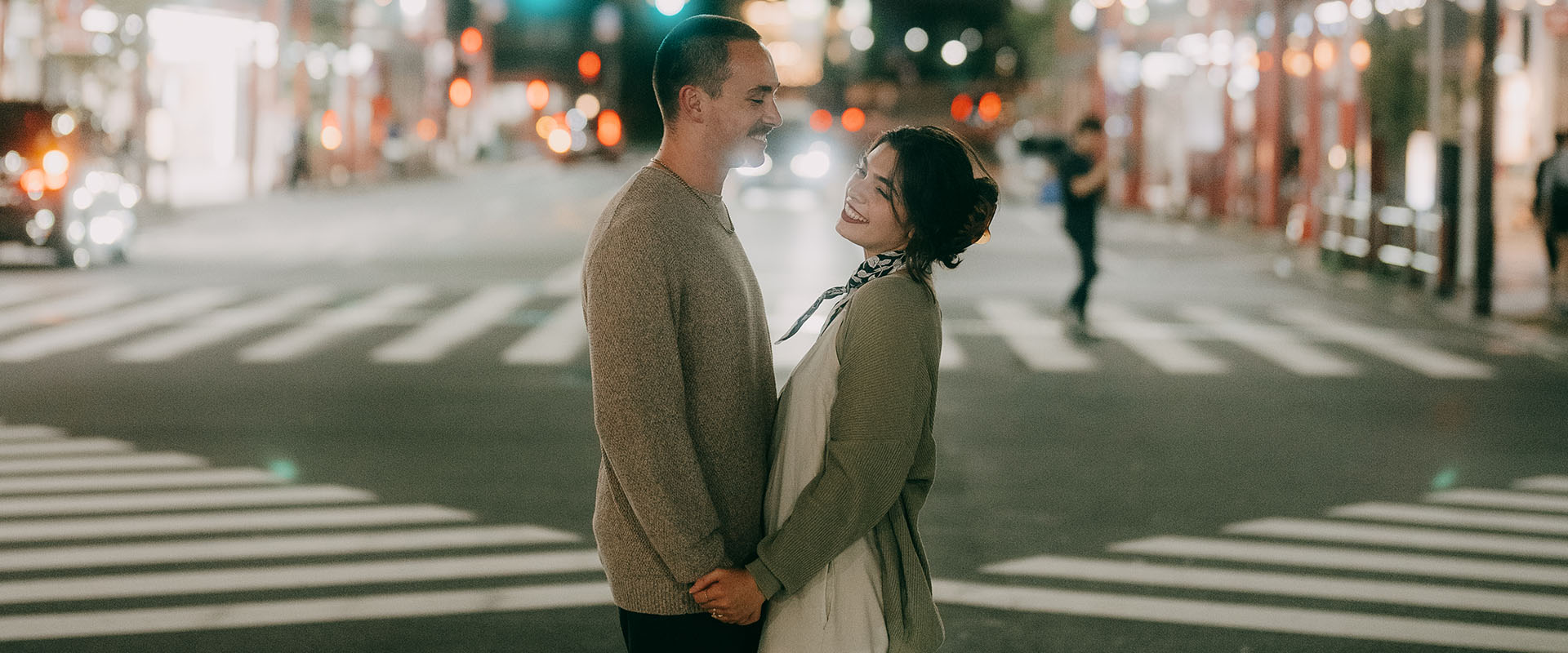 Man and woman standing holding hands on the street on their third date