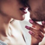 Woman holding man's chin and they are about to kiss as symbol for is it just sex