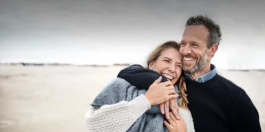 Dating after 40 symbolized by a man who strolls happily with his date at the beach