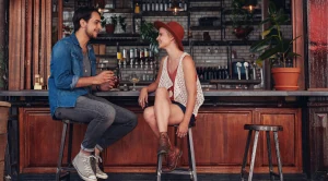 A couple talking, sitting in a pub.