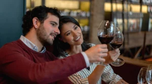 A couple looking at their wine glases at a wine tasting event.