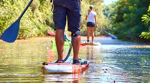 A couple paddleboarding on a date at the lake.