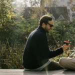Two men are sitting outside, laughing together—a symbol of gay dating