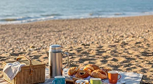A picnic with snacks and blanket at the beach.