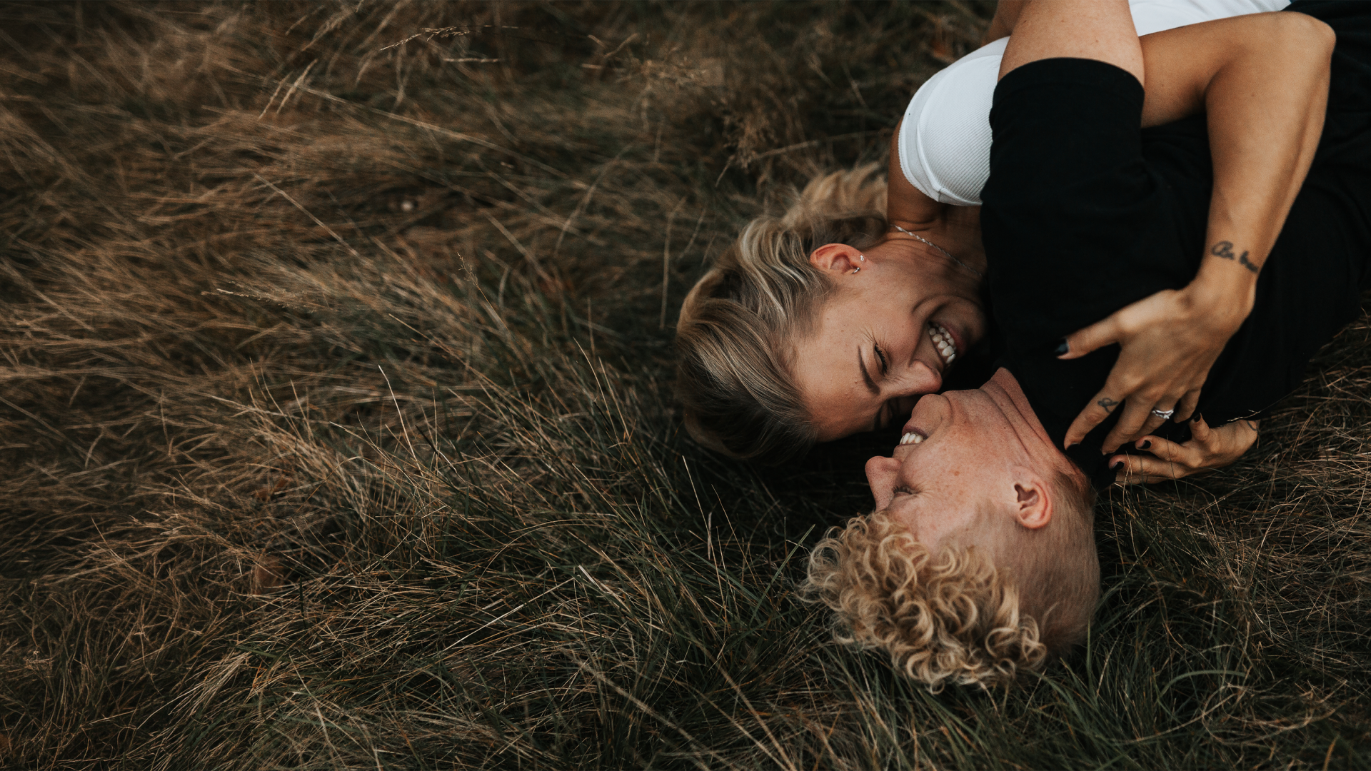 Two women are lying on the floor, embracing, as a symbol of lesbian dating