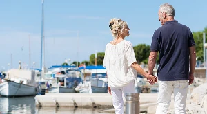 A couple walking side by side at the harbour.