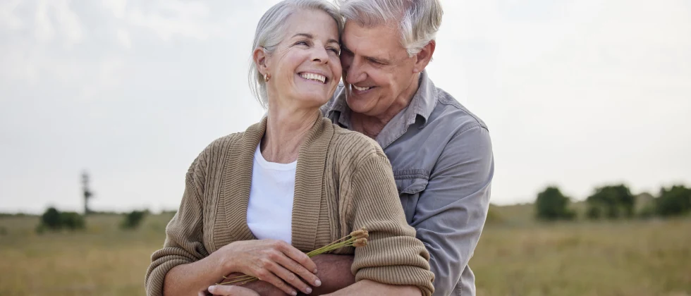 A couple hugging each other in the nature.