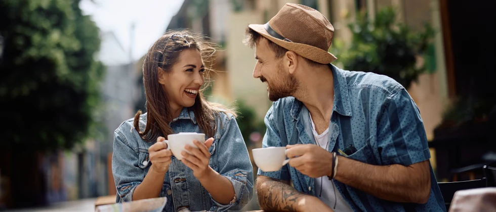 A couple drinking a cup of cofee together in the public.