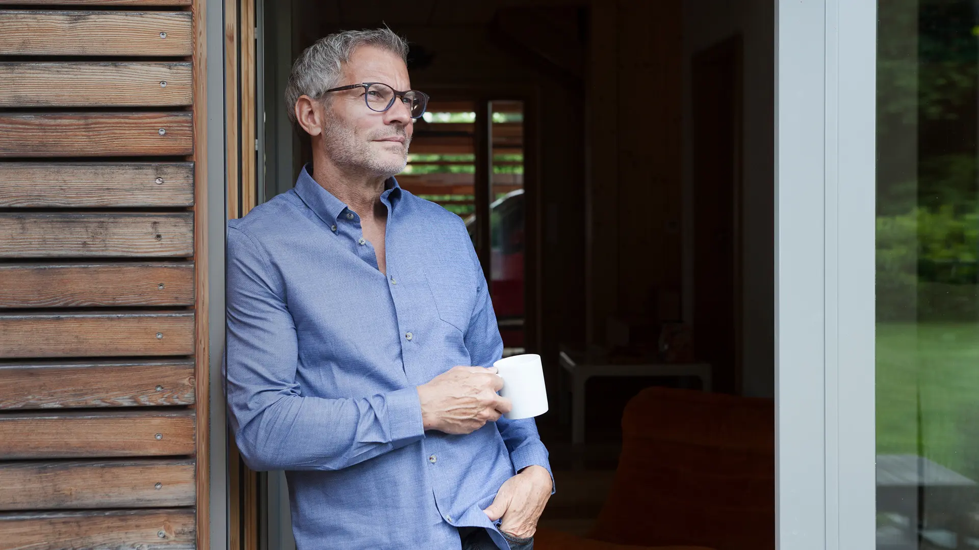 A men over 50 drinking coffee on his balcony