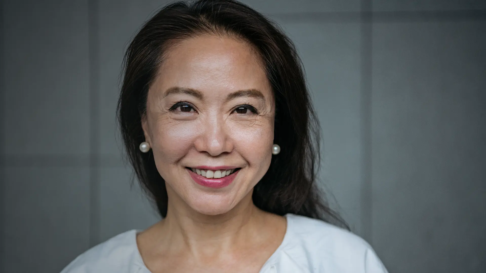 Mid-Life Chinese Single Woman smiling directly into the camera.